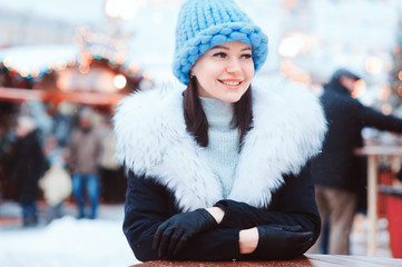 happy girl on christmas shopping at winter snowy Moscow city holiday market, buying souvenirs and gifts, New Year shopping concept