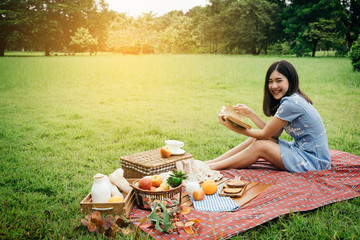 A girl going picnic in a park and reading a book