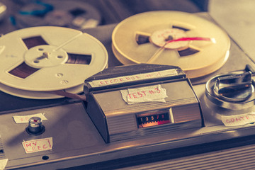 Old reel-to-reel tape recorder with microphone and roll of tape