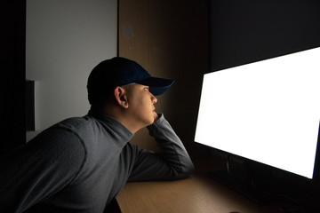 Side view of man Hacker sit at the computer monitor. in the dark room.