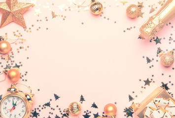 Naklejka na ściany i meble Christmas or New Year composition, frame, pink background with gold Christmas decorations, stars, snowflakes, balls, alarm clock, gift box and bottle of champagne, top view