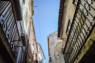 Fototapeta premium Typical portuguese streets, apartment windows and houses on traditional district scene in Lisbon, Portugal. historical structure view.