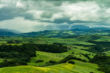 View of the mountainous meadow covered by dense clouds.