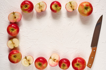 Frame of various fresh red apples with knife on the white concrete background. Top view with copy space for text