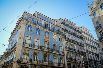Fototapeta premium Typical portuguese streets, apartment windows and houses on traditional district scene in Lisbon, Portugal. historical structure view.