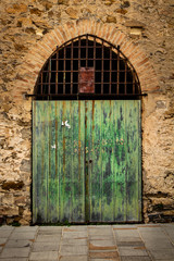 Fototapeta na wymiar Old and rustic green wooden door. Exterior door in a house of the middle evo.
