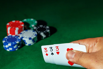 Casino games concept,Poker chips on gamble table , Light through background, winning hands of...