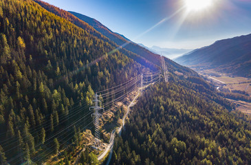 Aerial view of power line pylon in mountaineous area in Switzerland through valley in Canton of...