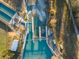 Fototapeta premium Aerial view of river dam in small river in Switzerland in evening sunlight
