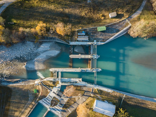 Aerial view of river dam in small river in Switzerland in evening sunlight