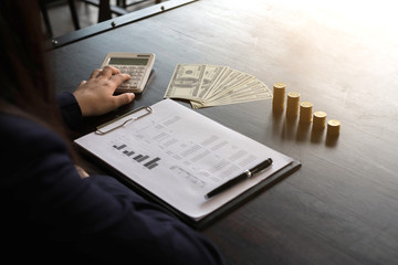 Businesswomen calculate the income from the export business on the wood table.Business concept.