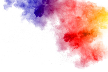 Abstract multi color powder explosion on white background.  Freeze motion of  dust  particles...