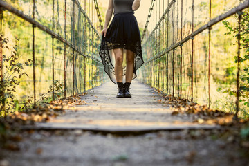 Traveler girl walks on a wood bridge