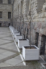 Fototapeta na wymiar View of regular row of white pots at Imperial Castle facade in Poznan, Poland