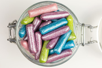 gummy candy in mermaid colors dusted with silver in a glass jar