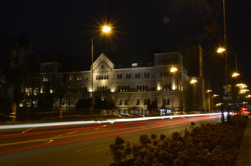 View of Imperial Castle facade in Poznan (Poland) at evening with beautiful dark blue sky background with blurred city lights