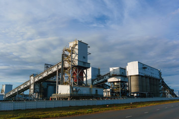 Fototapeta na wymiar Industrial landscape - storage and loading hopper for loose materials with inclined conveyor galleries