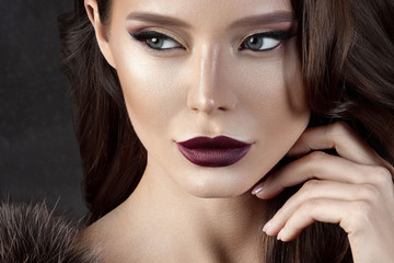 Luxurious young woman with perfect make-up with purple lipstick