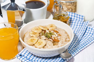 bowl of oatmeal with banana, honey and nuts for breakfast