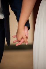 bride and groom hold hands