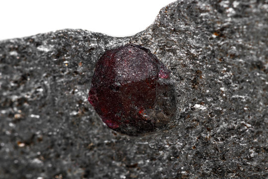 Macro mineral stone garnet  in the rock on a white background