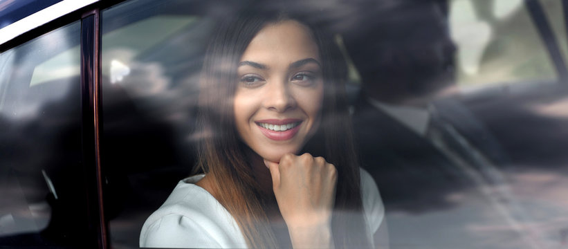 thoughtful business woman sitting in car backseat