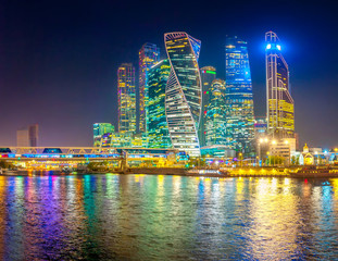 Fototapeta na wymiar Panorama of Skyscrapers of Moscow City with reflections in Moscow river at night. Modern architecture of Russia