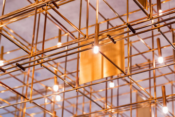 Modern metal lighting construction on the ceiling that looks like bamboo