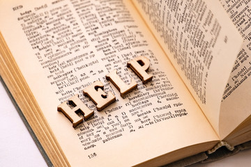 Russian-English translator. The concept of learning foreign languages. On the dictionary laid out the word help in wooden letters.
