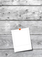 Blank square instant photo frame on grey wooden background