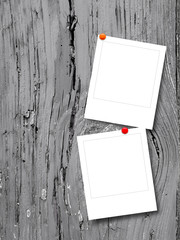 Two blank square instant photo frames on grey weathered wooden background