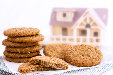 Homemade shortbread cookies made of oatmeal are stacked on white paper and cloth on home background. Concept food healthy snack for enjoy in holiday. With copy space for text.