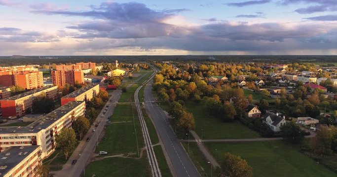 Aerial footage of foliage in small Estonian town at sunset. Autumn aerial flyover of scenic sunset in town.