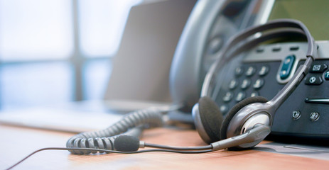 close up soft focus headphone call centre hotline at computer office help desk for background...