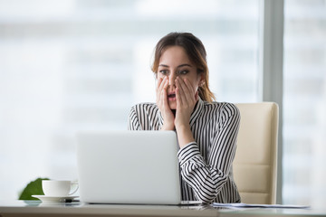 Shocked young woman looking at laptop screen. Frightened businesswoman receiving bad news, deal...