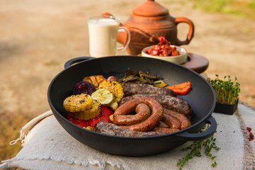 Grilled different meat sausages with vegetables and spices