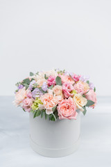 Beautiful spring bouquet in round box. Arrangement with various flowers. The concept of a flower shop. A set of photos for a site or catalogue. Work florist.