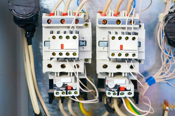Two electrical relays connected by wires on a metal background.