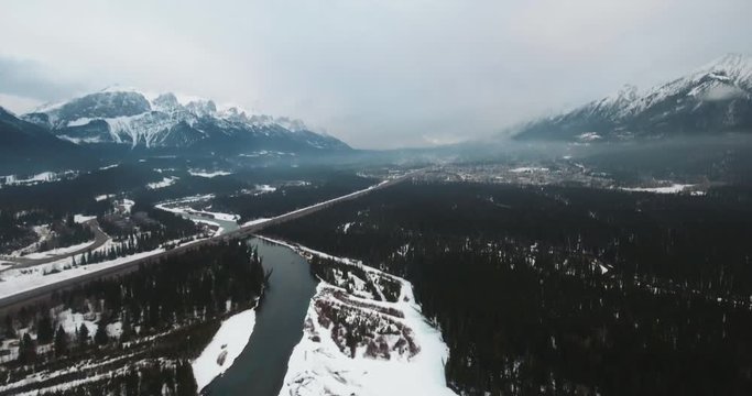 Aerial Drone Shot of Canmore Winter Establishing Shot River Mountains Cloudy