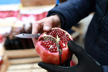 Seller demonstrates pomegranate