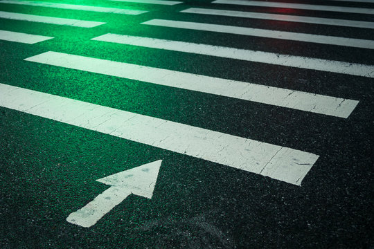 The Green Traffic Light On A Crosswalk At Night On Wet Asphalt