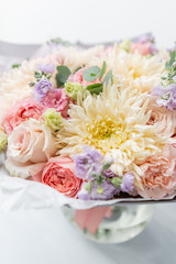 Beautiful spring bouquet in glass vase. Arrangement with various flowers. The concept of a flower shop. A set of photos for a site or catalogue. Work florist.