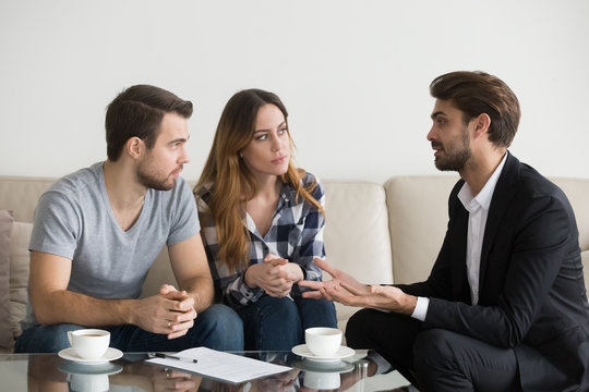 Young couple, family at meeting with realtor, interior designer, decorator, landlord, banker, financial advisor. Employee consulting, explaining Decision making doubting client customer