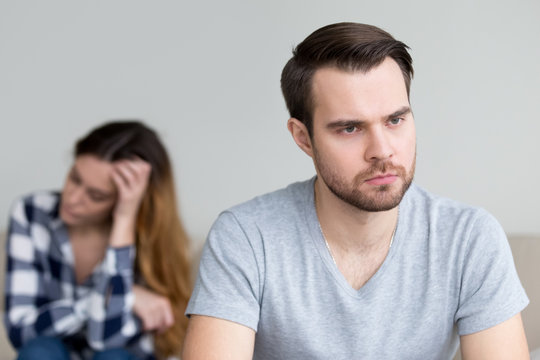 Head shot portrait sad, frustrated, desperate young man thinking of relationship problems. Troubles in family, misunderstanding, distrust. Young couple after quarrel