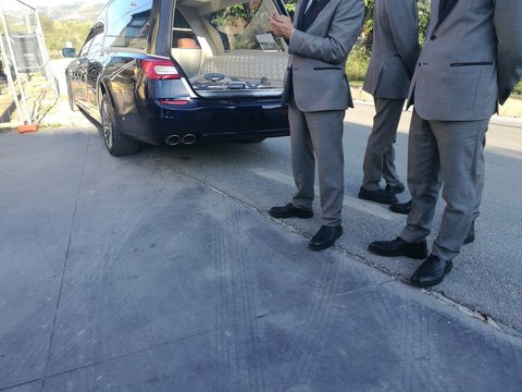 hearse open and empty with gravediggers