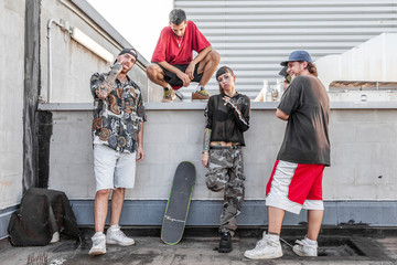 group of rappers posing against the wall on the metal rooftops