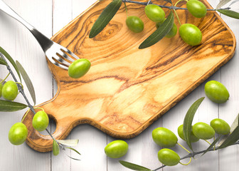 Olive branches on wooden rustic chopping board