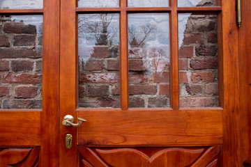 Red brick wall behind glass door or window.