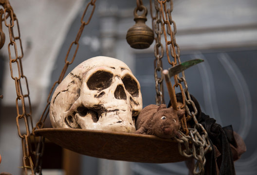 horizontal image of a fake skull used for decoration, photographed above an old scale