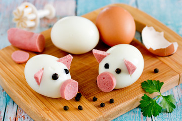 Boiled egg pigs, cute piglets made from eggs, sausage and black pepper peas, food art idea for kids